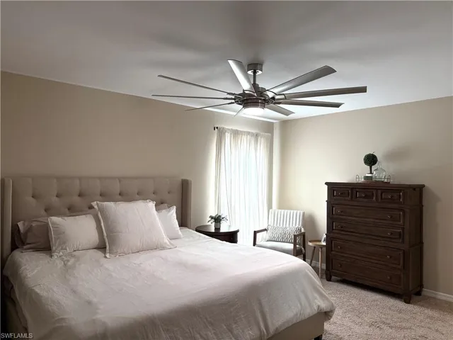 Carpeted bedroom featuring ceiling fan