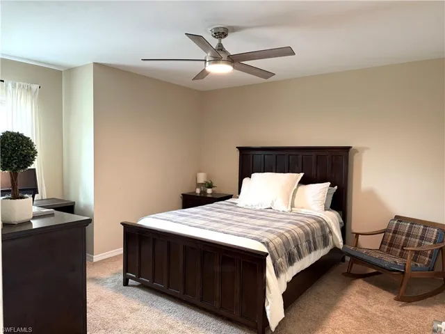 Bedroom with ceiling fan and light colored carpet