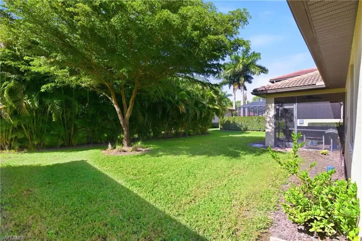 View of green lawn featuring a sunroom