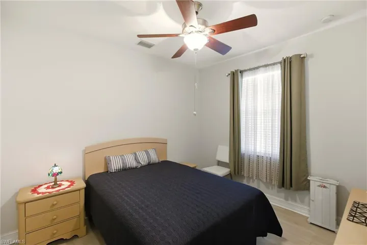 Bedroom with ceiling fan and light wood-style flooring