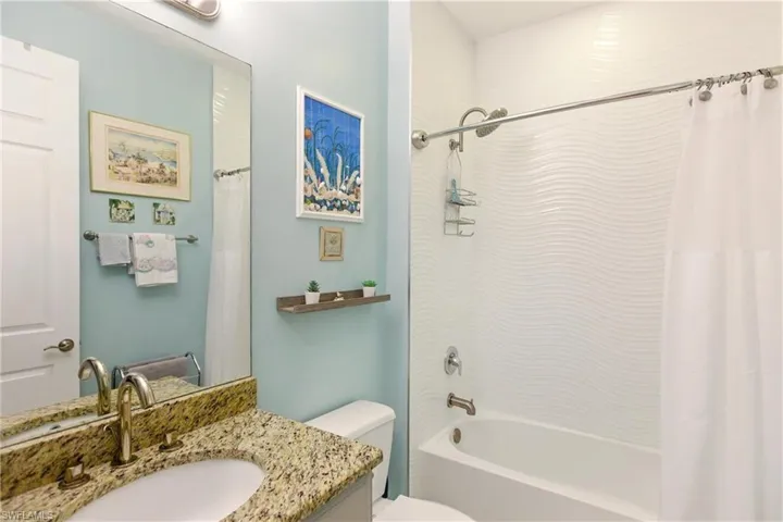 Bathroom featuring shower / tub combo with curtain and vanity