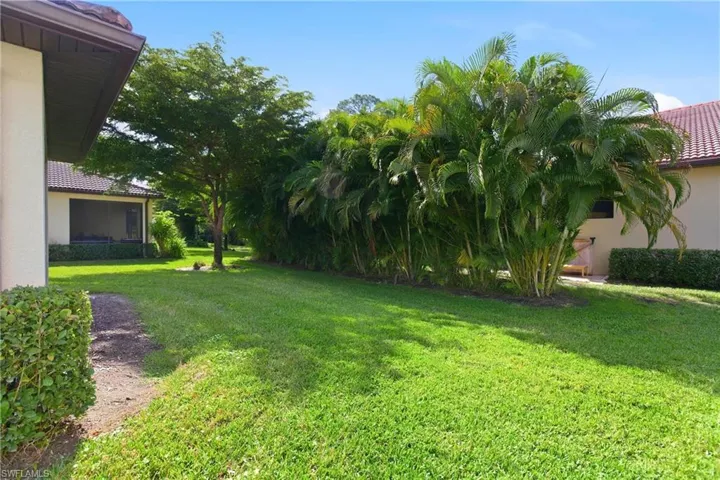 View of green lawn featuring a sunroom