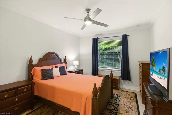 Bedroom with ceiling fan and crown molding