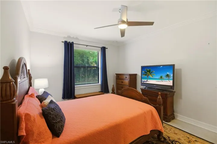 Bedroom featuring crown molding, a ceiling fan, and wood finished floors