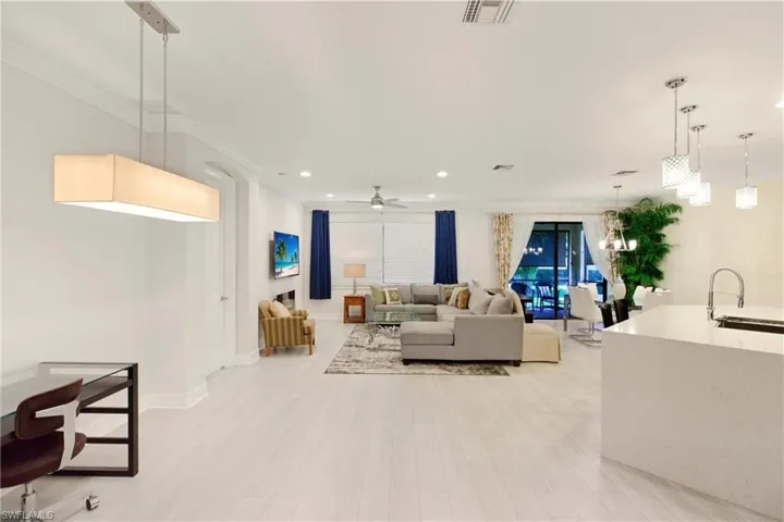 Living area with ceiling fan, ornamental molding, light wood-style floors, and recessed lighting