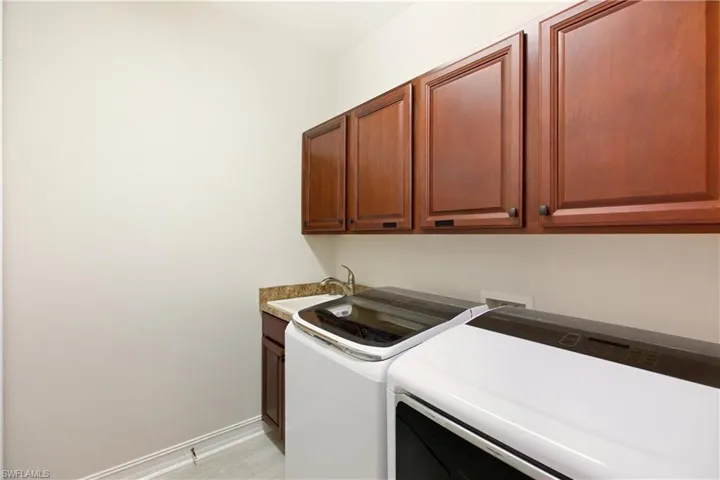 Laundry area featuring cabinet space and washing machine and clothes dryer