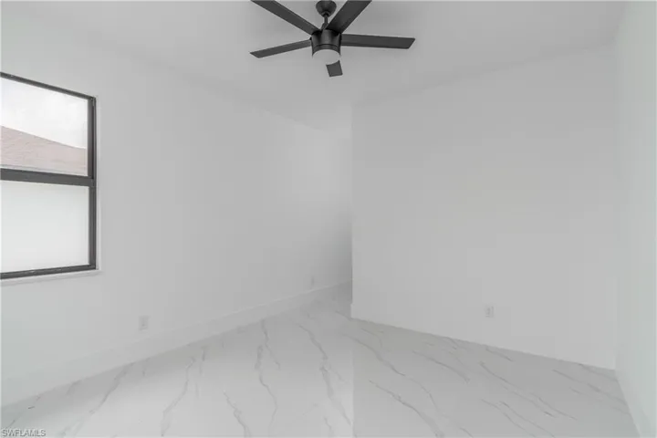 Tiled empty room with ceiling fan
