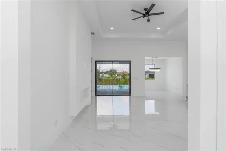 Tiled spare room with ceiling fan and a raised ceiling