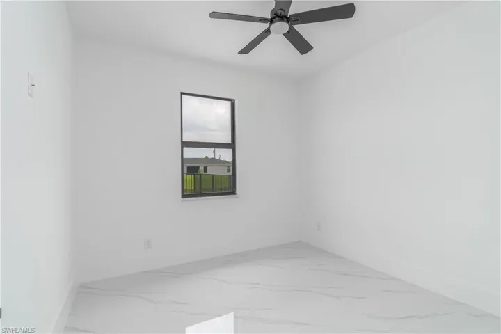 Unfurnished room with tile floors and ceiling fan