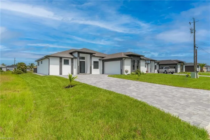 View of front of property featuring a front yard and a garage