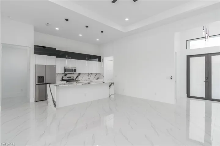 Kitchen featuring hanging light fixtures, tasteful backsplash, light tile flooring, and stainless steel appliances