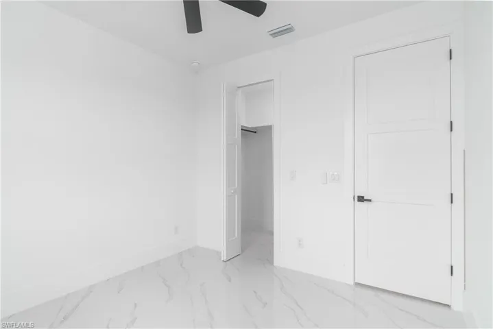 Unfurnished bedroom with a closet, ceiling fan, and light tile floors
