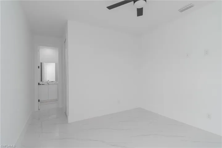 Tiled spare room with ceiling fan