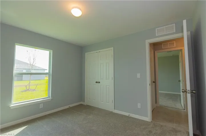 Unfurnished bedroom with carpet and a closet