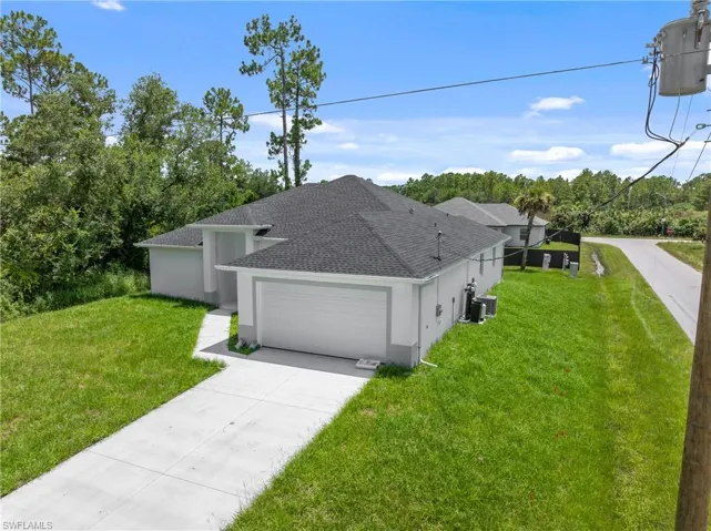View of front facade with a garage, cooling unit, and a front yard