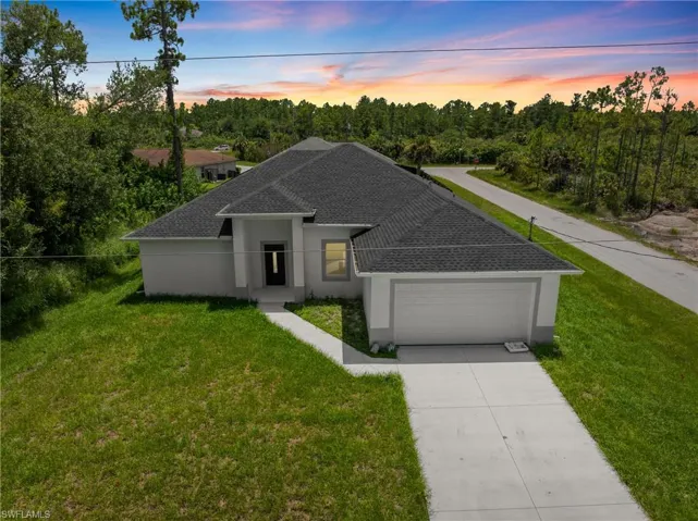 View of front of property with a garage and a yard