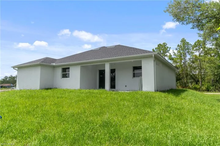 Back of house with a yard