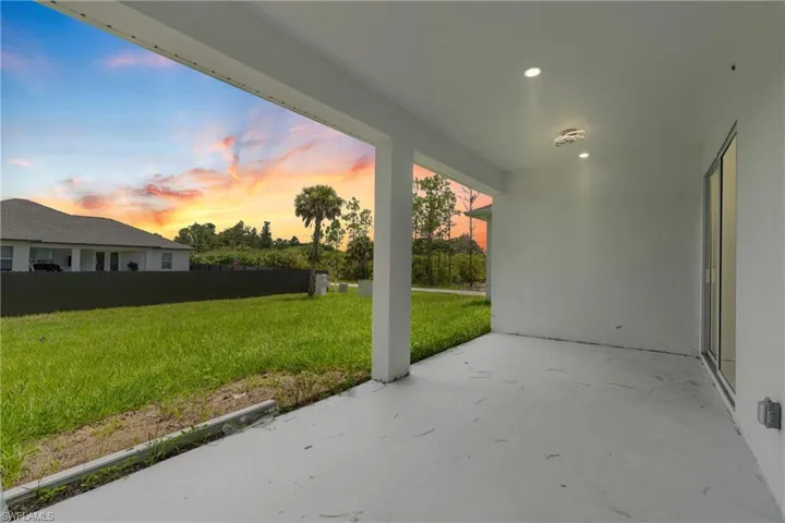 Patio terrace at dusk featuring a lawn