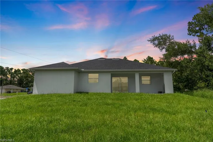 Property exterior at dusk with a lawn