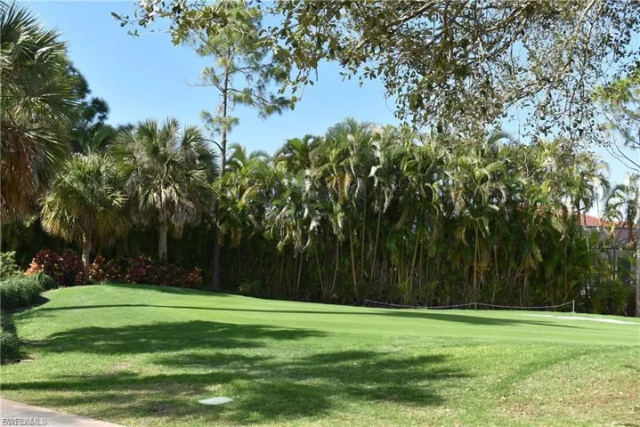 View of community with view of golf course and a lawn