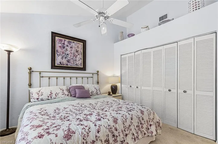 Bedroom with carpet, a ceiling fan, a closet, and a high ceiling