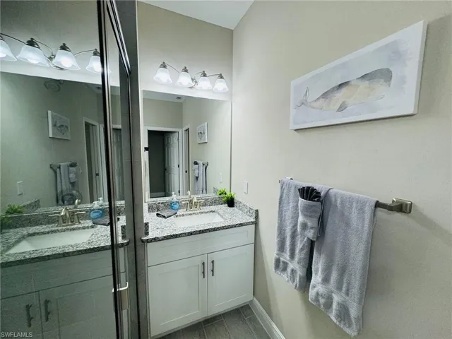 Full bathroom with vanity and baseboards
