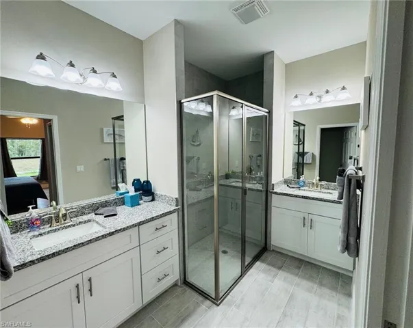Ensuite bathroom with two vanities and a shower stall