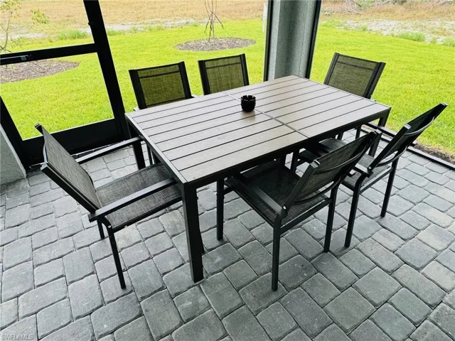 Sunroom / solarium with outdoor dining area and a patio