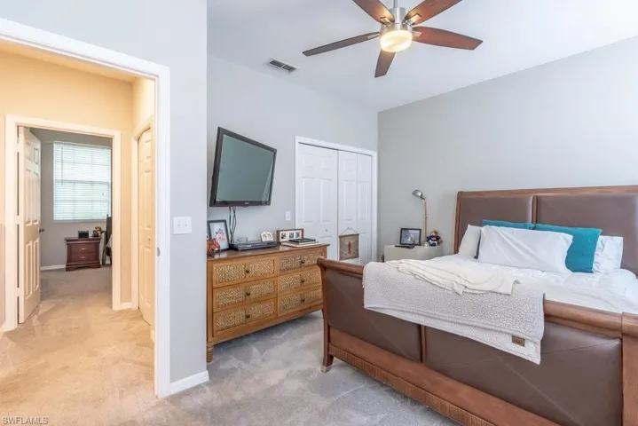 Carpeted bedroom with a closet and ceiling fan