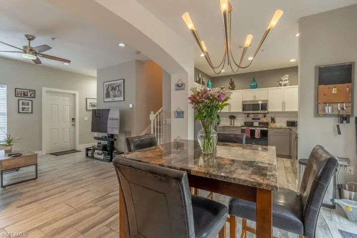Dining room featuring ceiling fan with notable chandelier and light hardwood / wood-style flooring