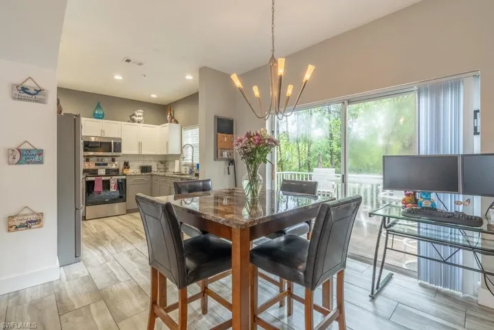 Dining room featuring sink, a chandelier, and light hardwood / wood-style floors