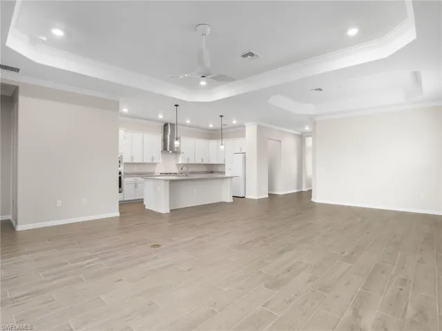 living room featuring a raised ceiling, crown molding, light wood-like tile floors, ceiling fan, and recessed lighting