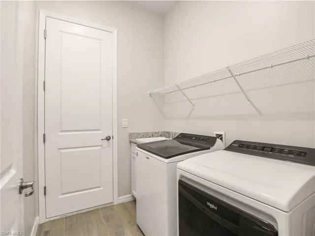 Laundry area featuring washing machine and dryer, plus laundry sink