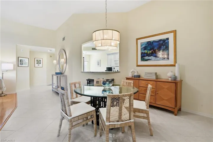 Dining area with a towering ceiling and light tile patterned flooring
