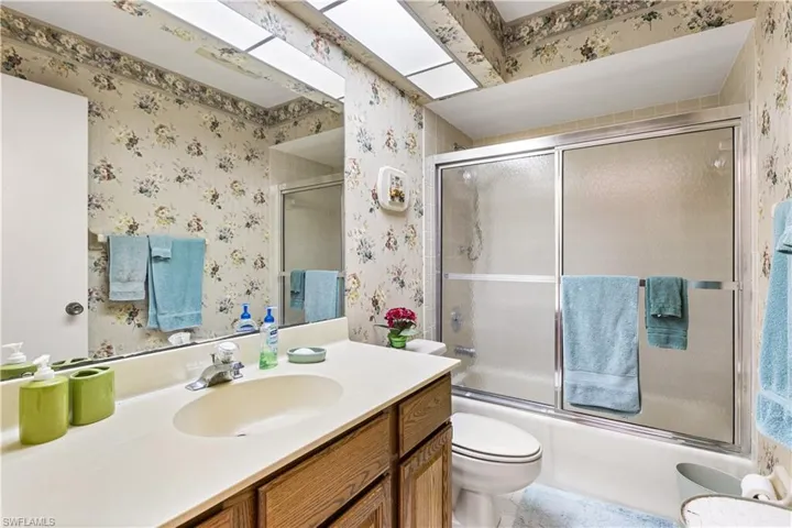 Full bathroom featuring vanity, toilet, and enclosed tub / shower combo