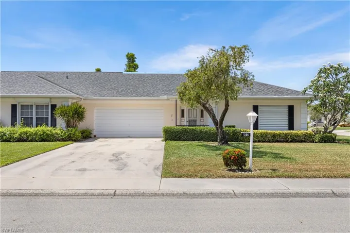Ranch-style home featuring a front yard and a garage