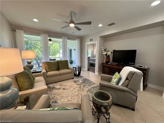 Living room with light tile patterned flooring and ceiling fan