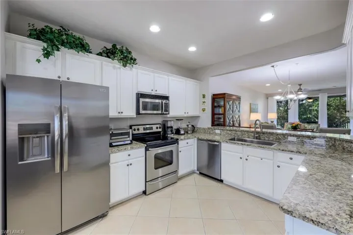 Kitchen featuring light tile patterned flooring, sink, kitchen peninsula, and stainless steel appliances