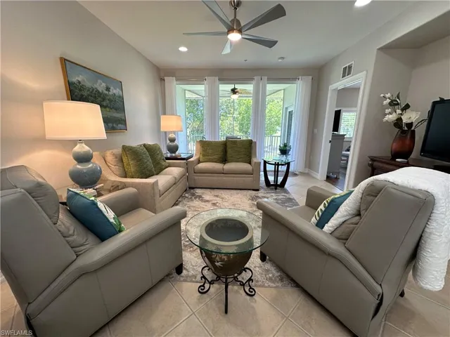 Tiled living room with ceiling fan and a wealth of natural light