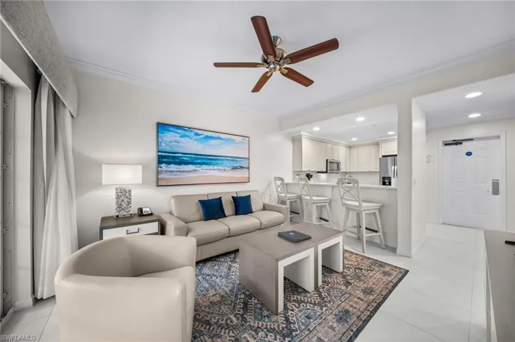 Living room with a ceiling fan, crown molding, and recessed lighting