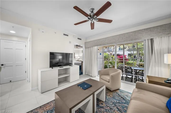 Living area featuring ornamental molding, ceiling fan, and light tile patterned floors