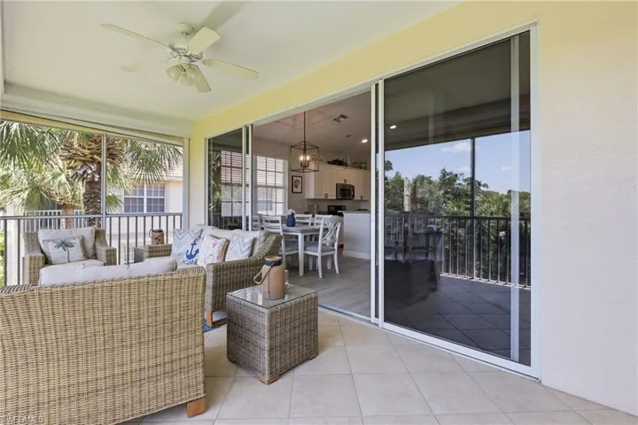 Screened outdoor patio featuring tile flooring and a ceiling fan