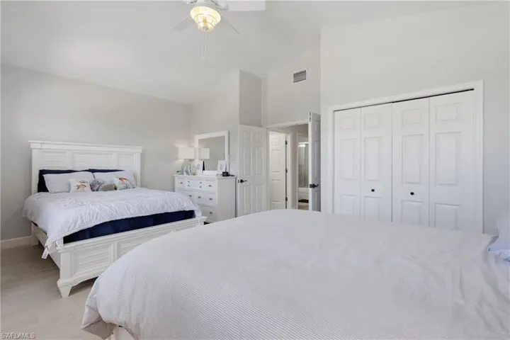 Spacious room featuring vaulted ceilings, a ceiling fan with integrated lighting, and light-toned flooring