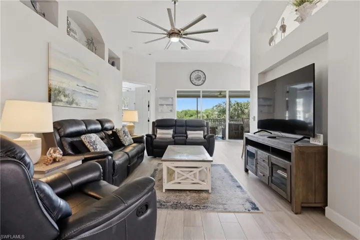 Spacious living area featuring vaulted ceilings and light wood-finish flooring