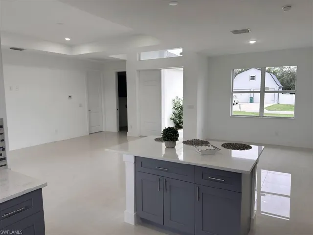 Kitchen with open floor plan, light stone countertops, recessed lighting, and a center island