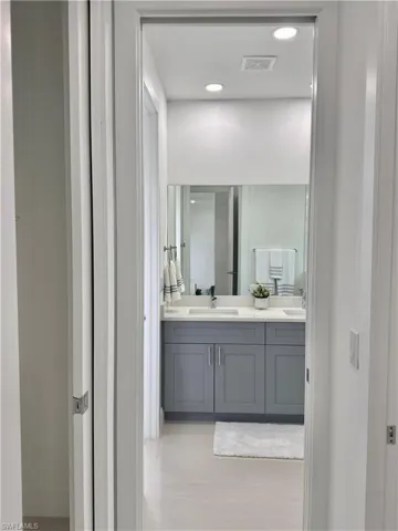 Bathroom featuring double vanity, light tile patterned floors, and recessed lighting