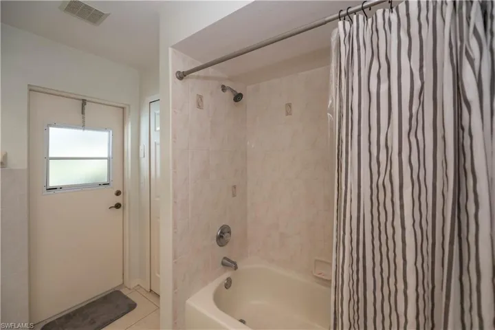 Bathroom featuring tile patterned floors and shower / tub combo with curtain