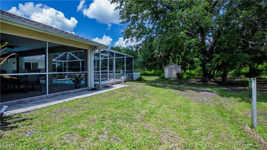 View of yard featuring a patio area, a storage shed, and a lanai