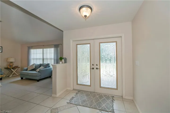 Tiled entryway featuring french doors