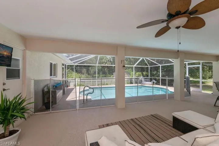 View of swimming pool featuring ceiling fan